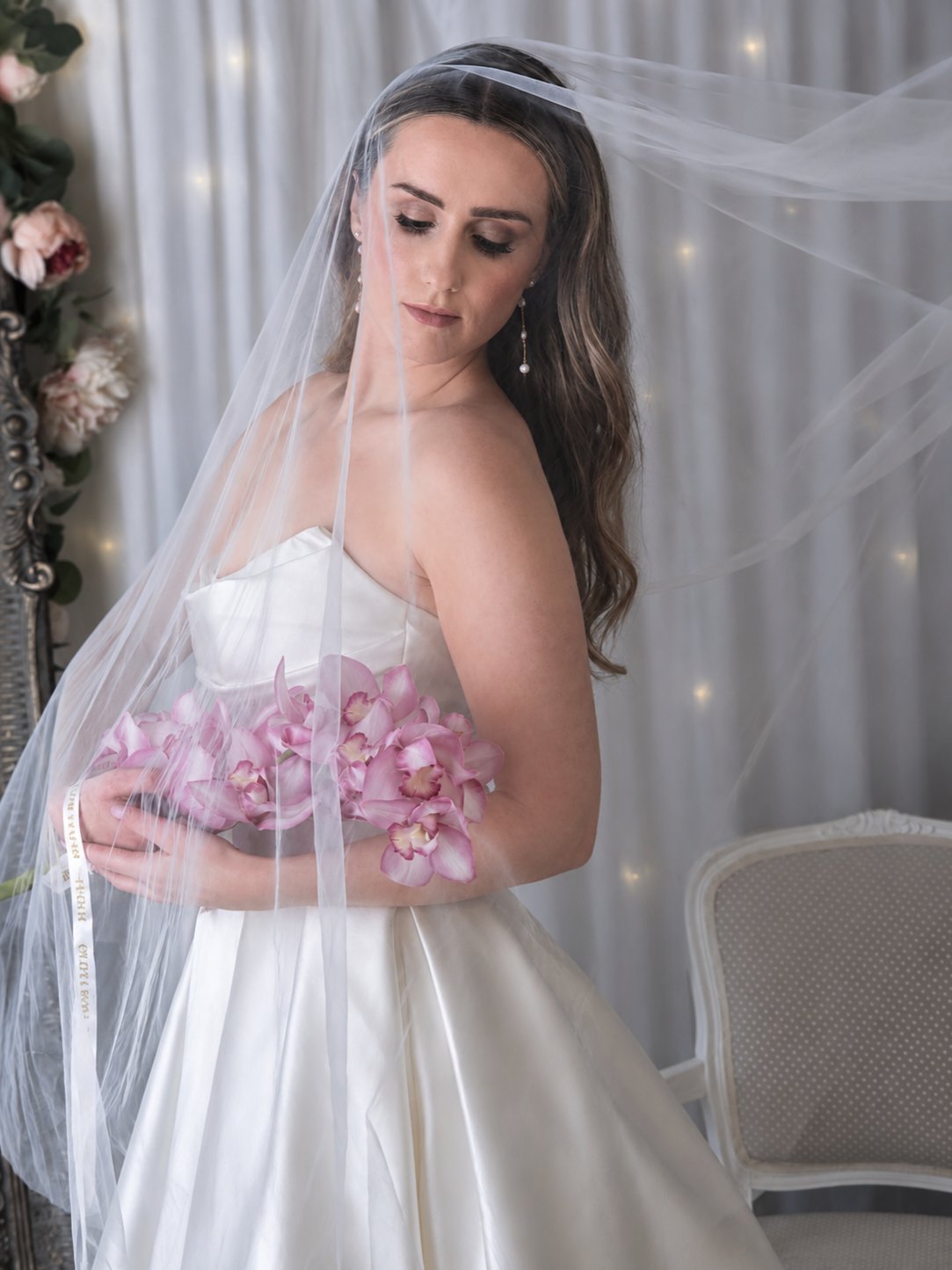 Bride with veil and pink bouquet in the Olivia Rose Bridal boutique